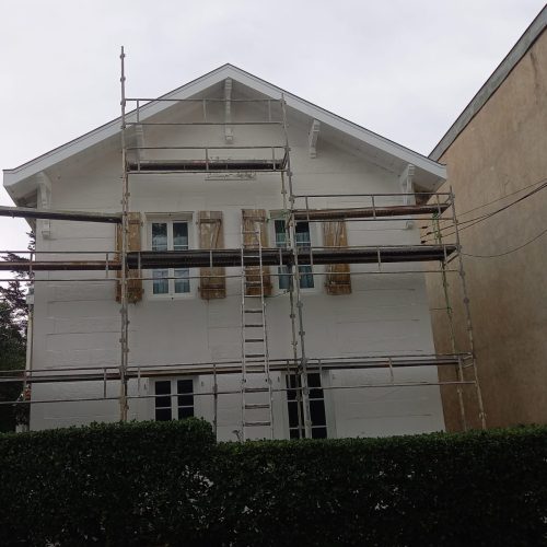 Chantier de rénovation et peinture extérieure de façade de maison dans le Lot-et-Garonne avec échafaudage complet