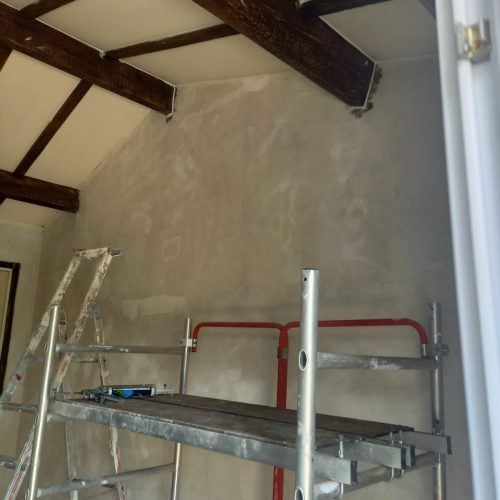 Préparation des murs pour travaux de peinture intérieure avec poutres apparentes dans une maison du Lot-et-Garonne